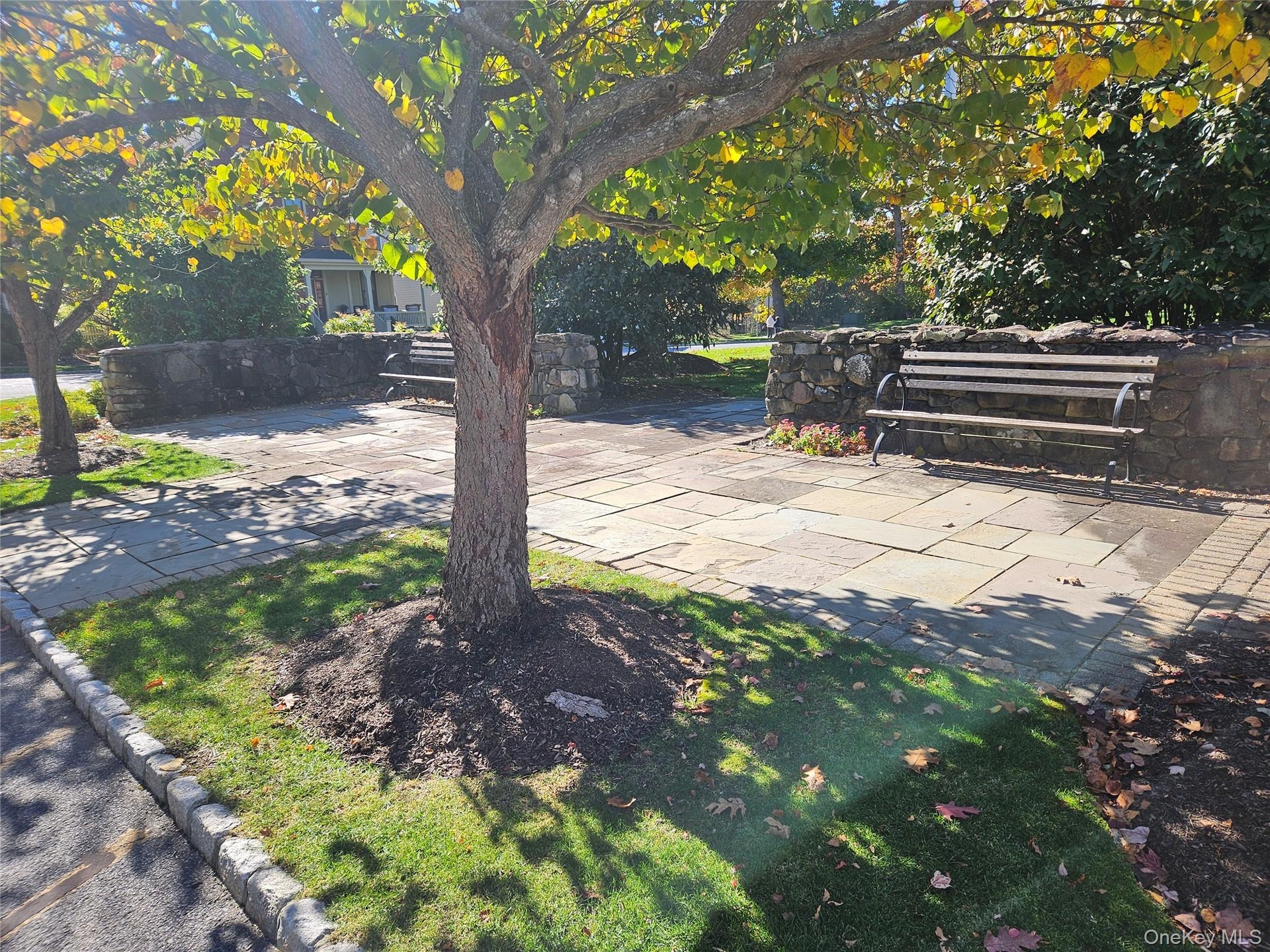 A place to sit, adjoining a green across from both the Community Center and Postal Center.