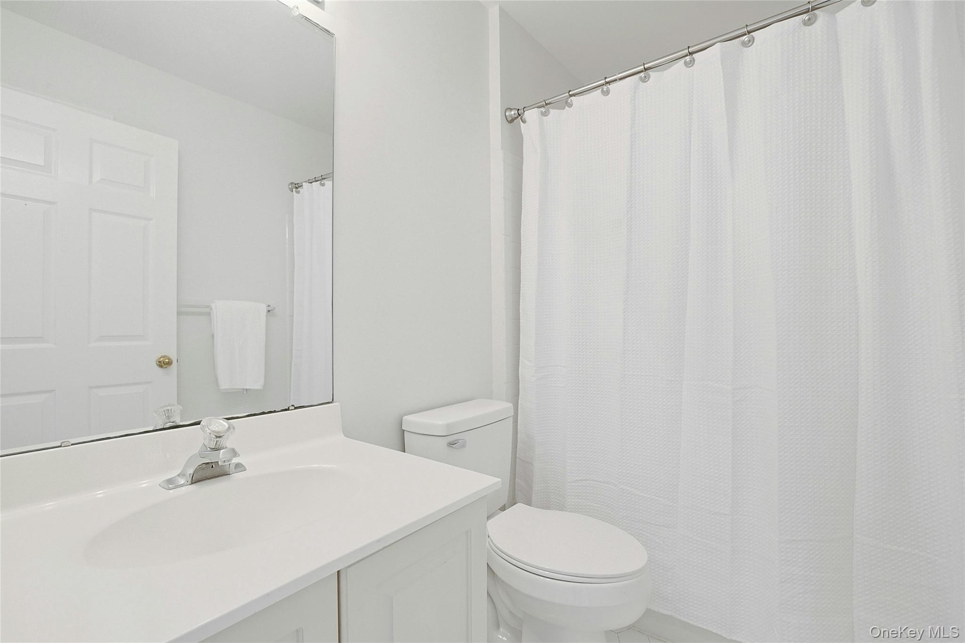 Main Bathroom on top level has bath and light fixtures, light tiles and line closet