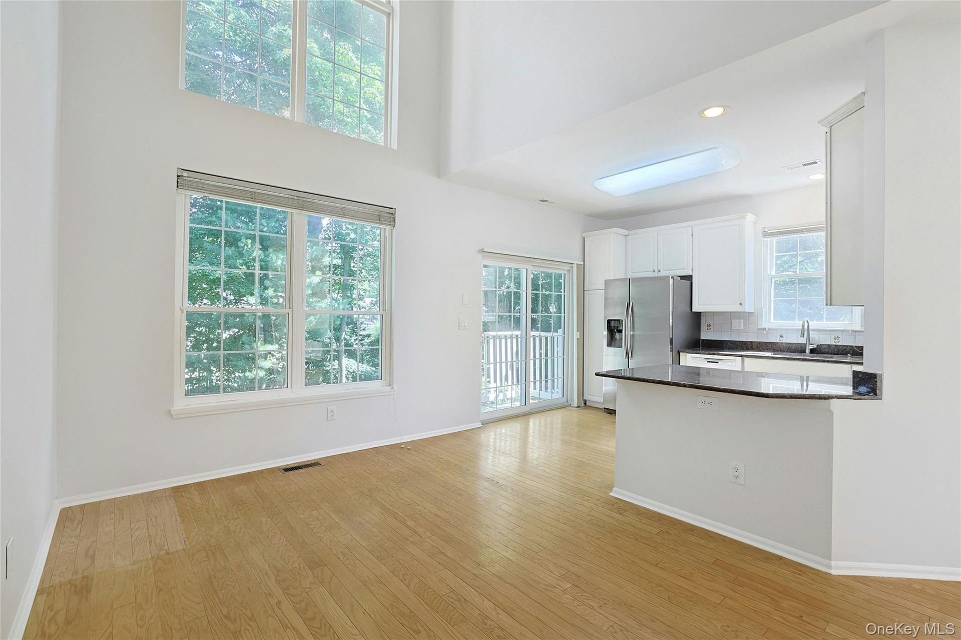 Bright kitchen with light cabinetry, peninsula and lots of windows. Access to private patio
