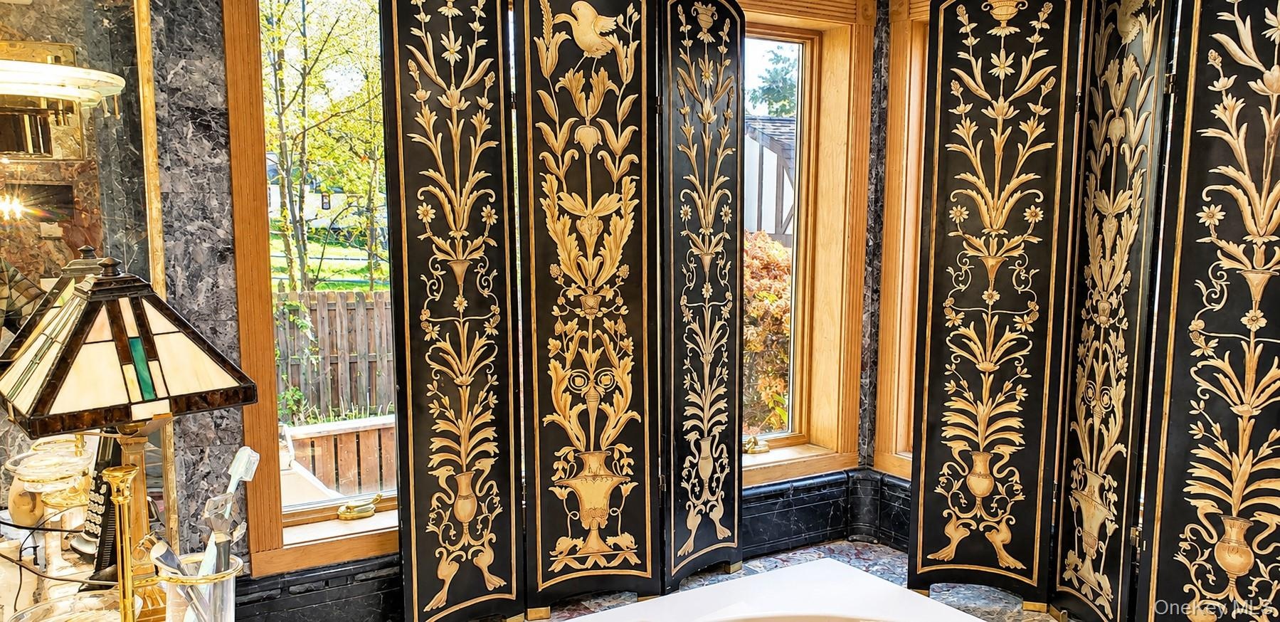 Natural stone wall surfacing with polished finish, expansive windows with wood-trim framing, and built-in stone vanity