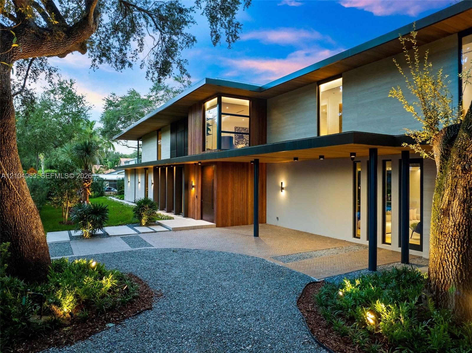 Contemporary architectural exterior featuring a combination of wood-paneled siding and smooth finish surfaces, extensive roof overhangs, custom-design