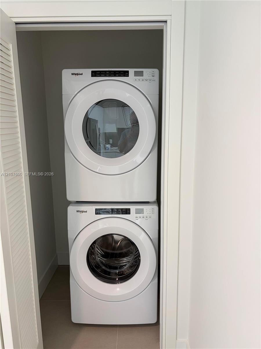 Stacked front-load washer and dryer unit enclosed within a dedicated laundry closet