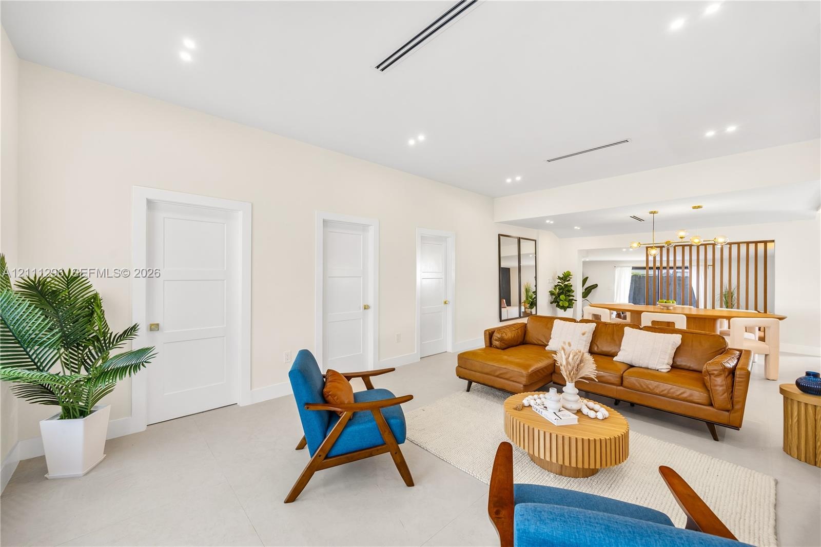 Neutral interior featuring recessed lighting, smooth ceiling finish, three-panel interior doors, light-toned tile flooring, and a decorative vertical 