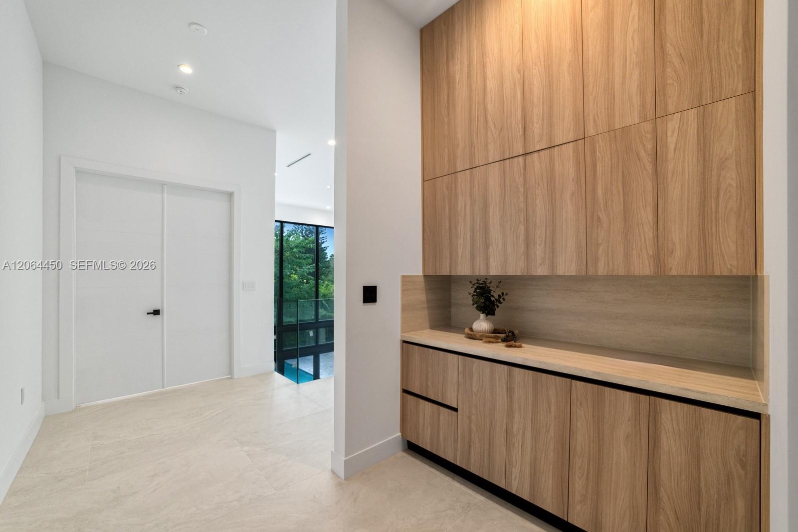 Built-in cabinetry featuring wood-finish cabinetry, light-toned countertop, recessed ceiling lighting, and smooth surface flooring
