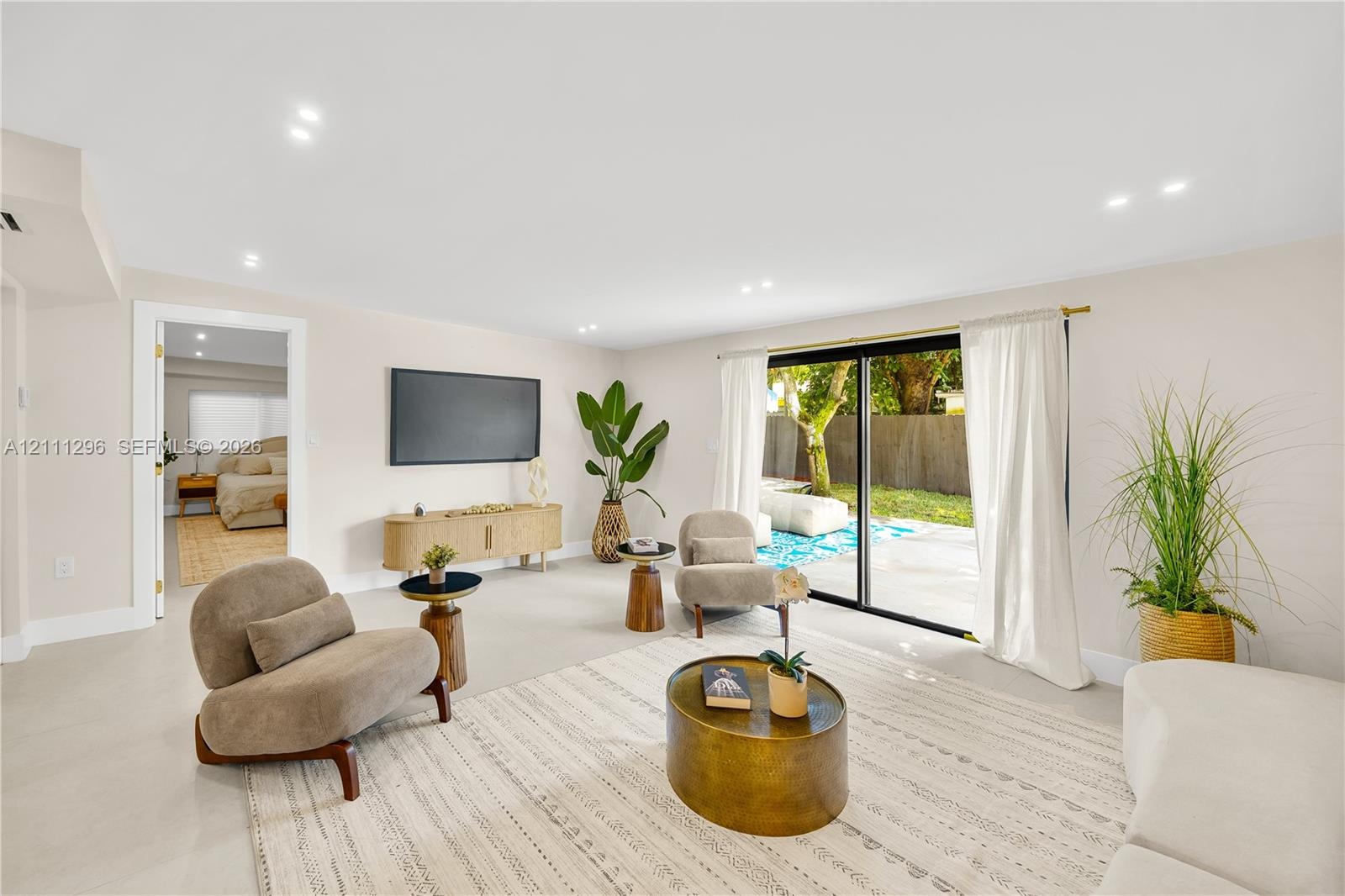 Neutral-toned interior featuring recessed lighting, polished light-colored flooring, and large sliding glass doors