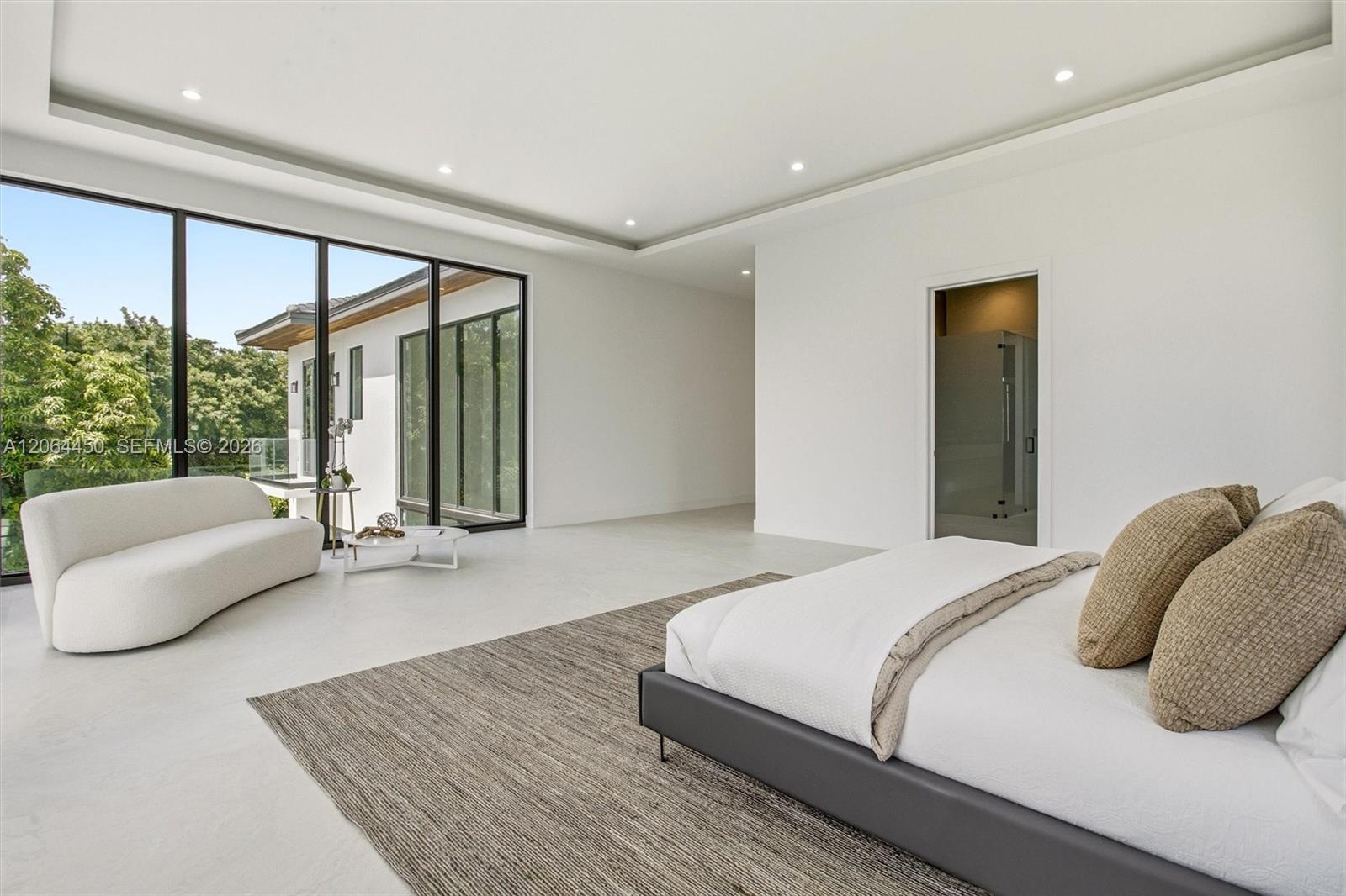 Floor-to-ceiling black-framed windows, recessed lighting, tray ceiling, and smooth-finish flooring