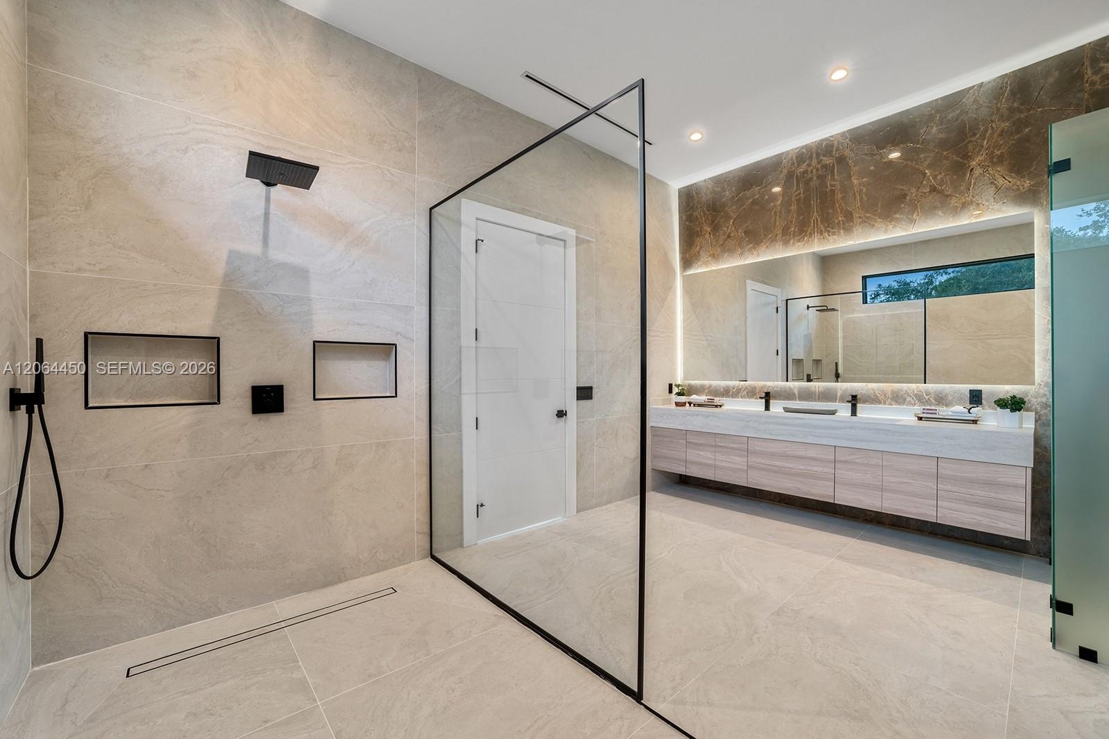 Walk-in shower with a glass enclosure, dual rainfall showerheads, and dual built-in wall niches