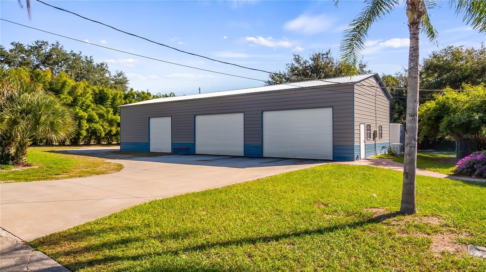HUGE 30X75 Metal Building installed in October of 2022, has 6 large bay doors, some have electric openers. The completely paid off solar panels are lo