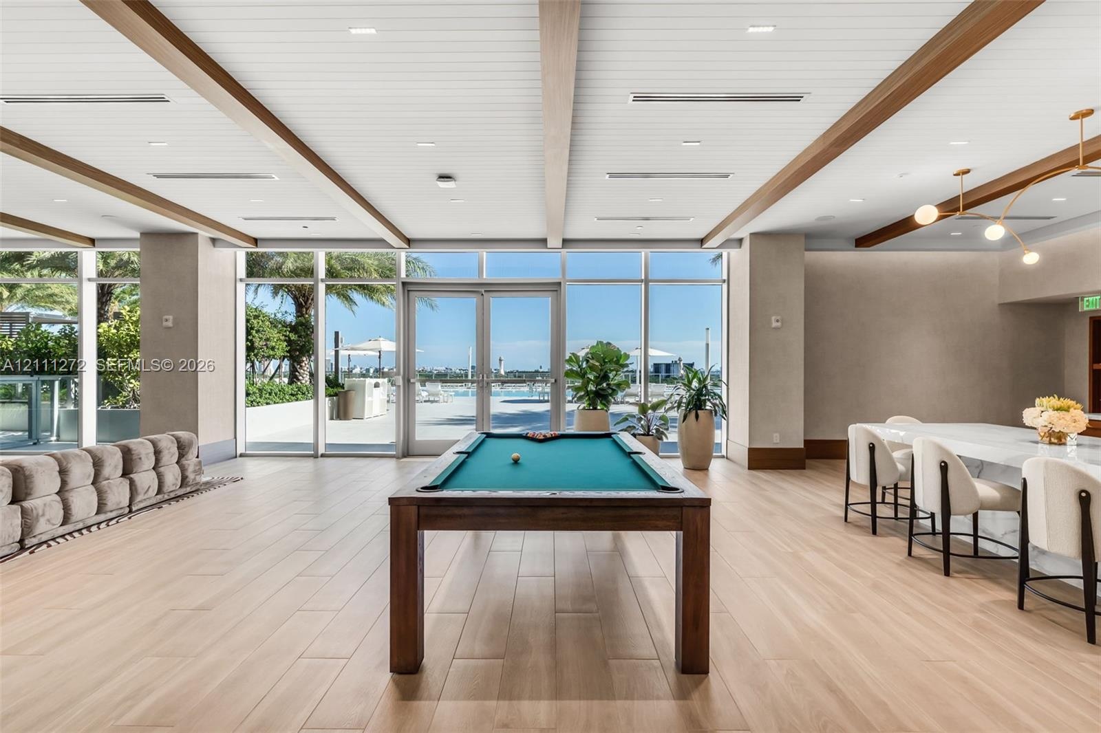 Common area featuring floor-to-ceiling windows, wood-finish tile flooring, recessed lighting, and wood-beam ceiling accents