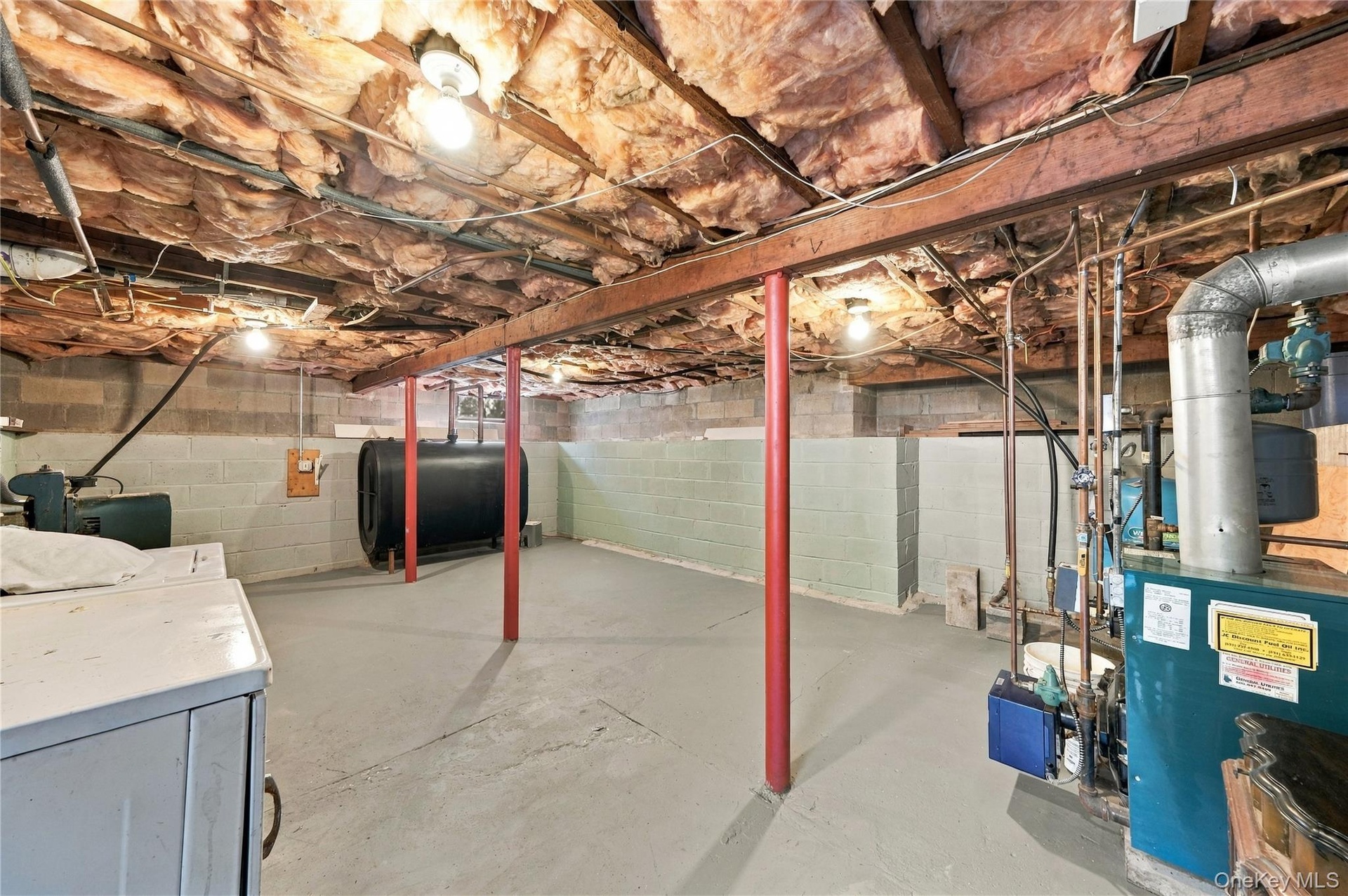 Unfinished lower level featuring concrete masonry unit walls, painted concrete flooring, exposed ceiling joists with fiberglass batt insulation, struc