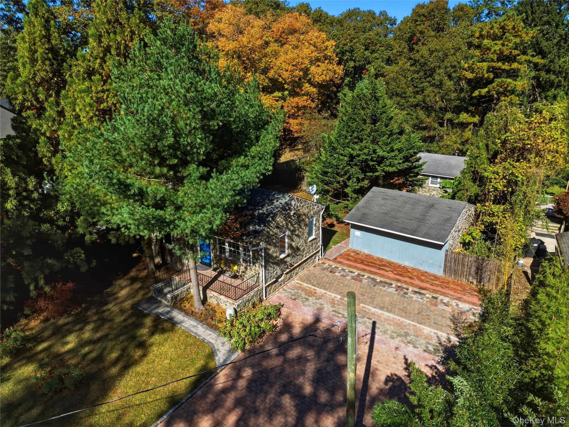 Aerial view of detached garage and driveway with natural stone pavers