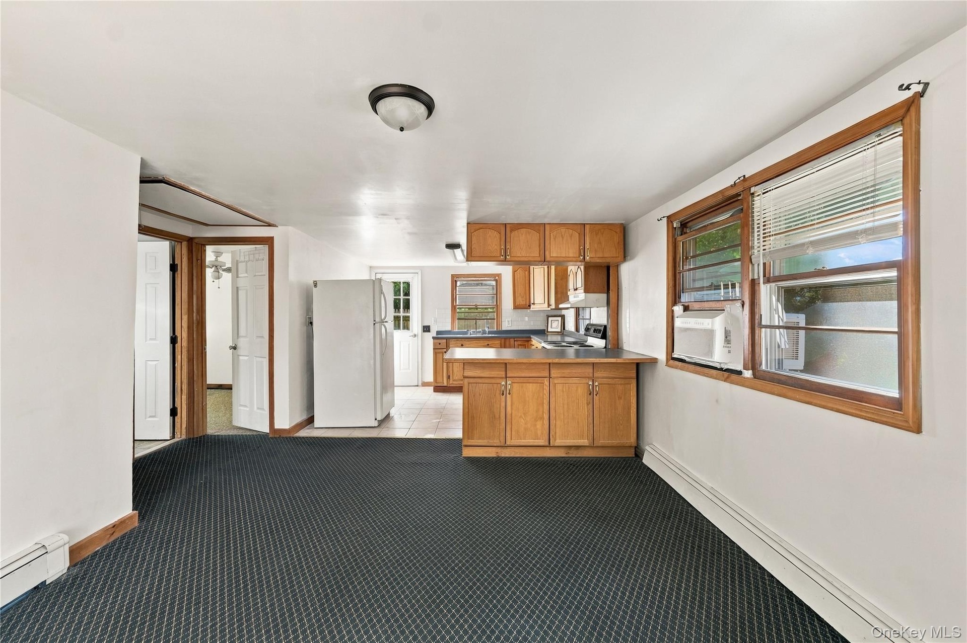 Kitchen featuring solid wood cabinetry, a breakfast bar, and neutral tile flooring