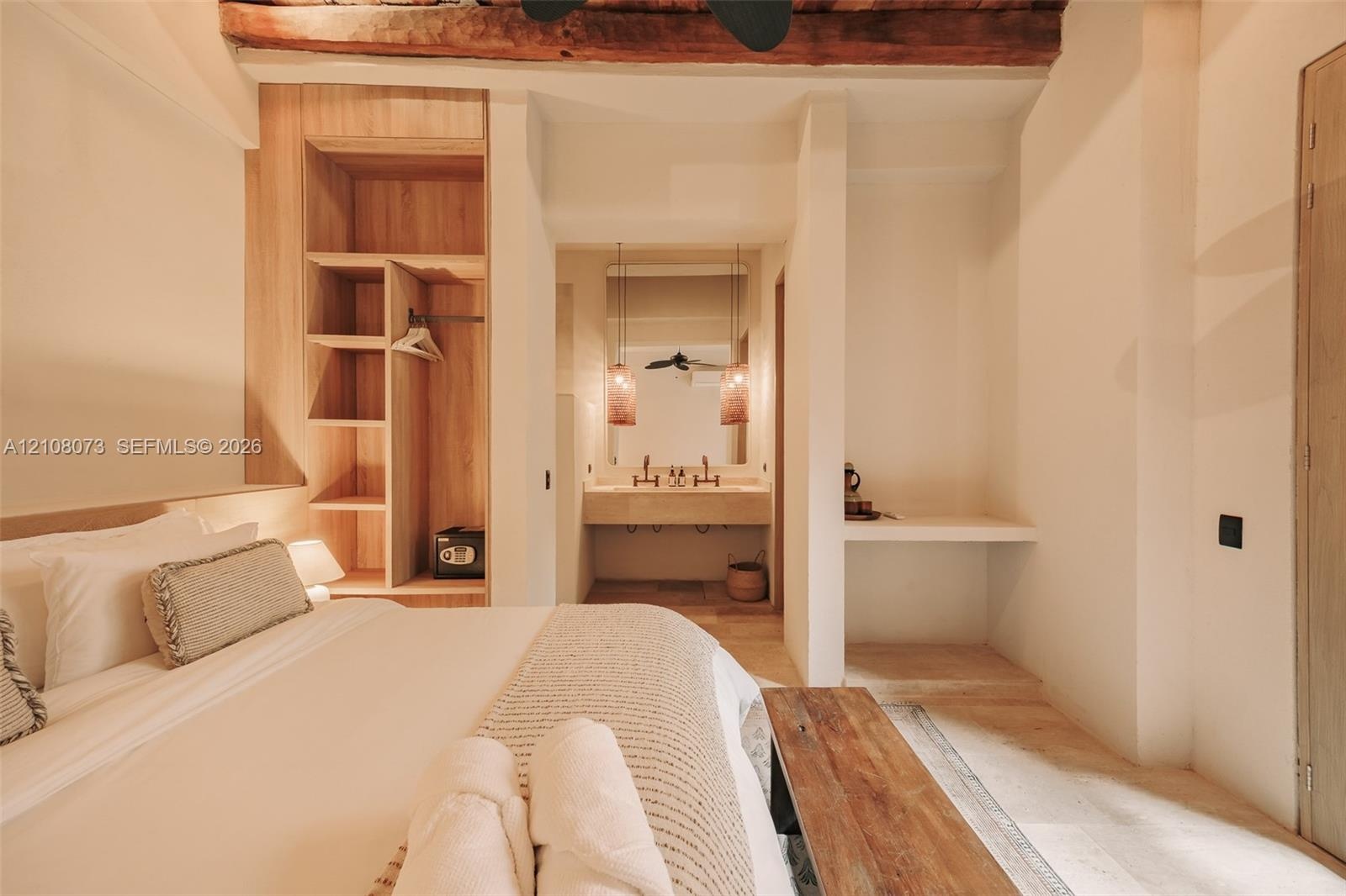 Exposed wooden ceiling beams, integrated wood-finish shelving, natural stone vanity, pendant lighting, and stone flooring