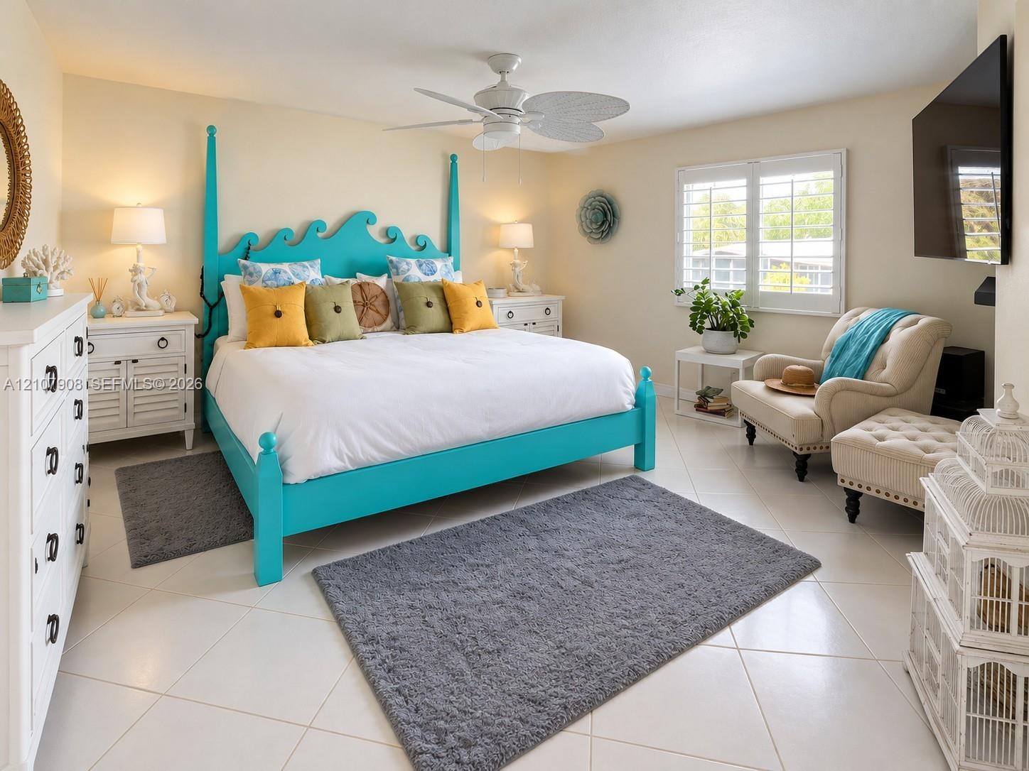 Room featuring neutral tile flooring, white plantation shutters, and a ceiling fan with leaf-style blades