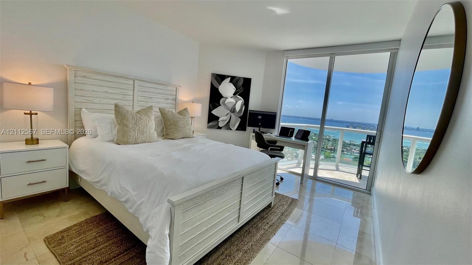 Polished stone flooring, floor-to-ceiling sliding glass doors, and a private balcony