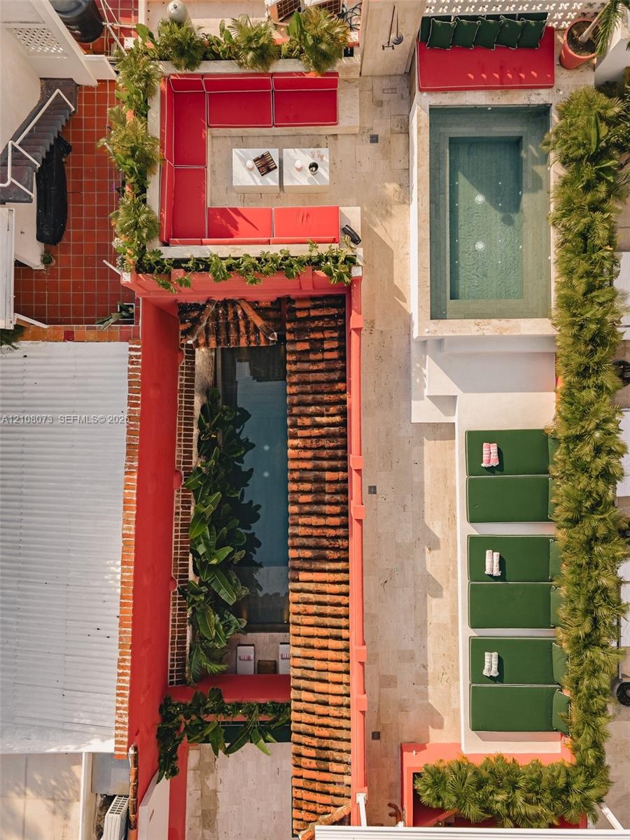 Outdoor courtyard featuring a swimming pool, stone-finish decking, built-in masonry seating, clay tile roofing, and integrated landscaping