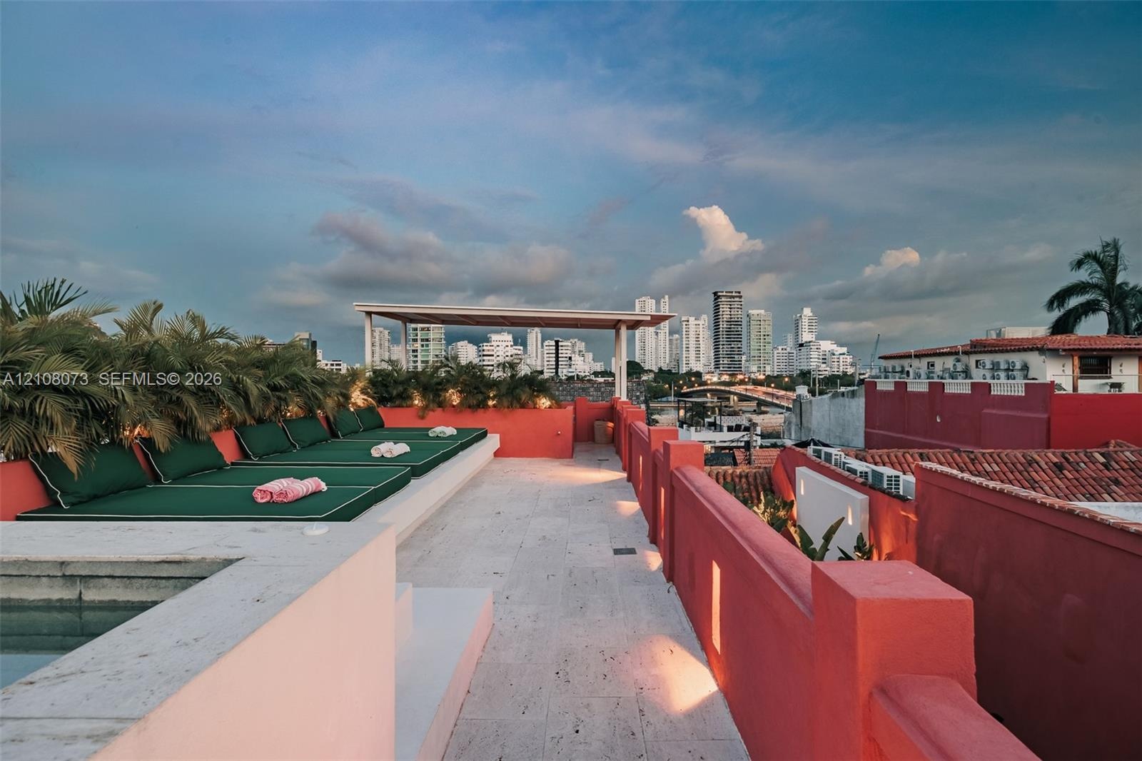 Rooftop terrace featuring stone flooring, a built-in pool, a covered pergola, and masonry perimeter walls