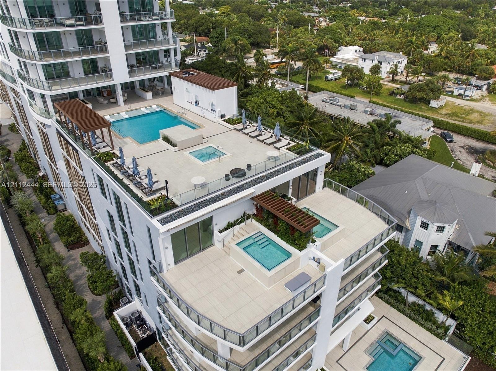 Multi-level terrace architecture featuring tiered swimming pools, integrated spas, glass balustrades, and pergola-covered outdoor areas
