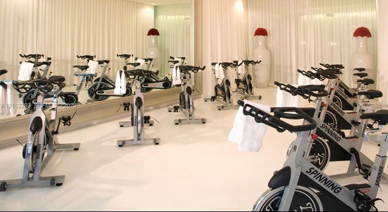 Fitness center featuring wall-to-wall mirrors and high-gloss flooring