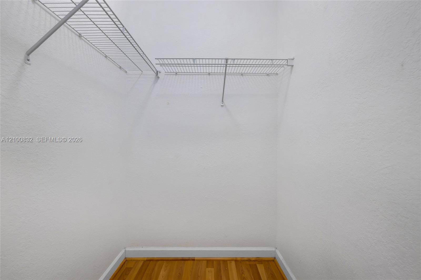 Storage area featuring wood-finish flooring and installed wire shelving