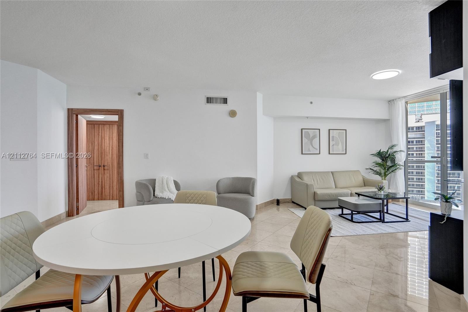 Polished stone flooring, floor-to-ceiling glass sliding door, and wood-finish interior door