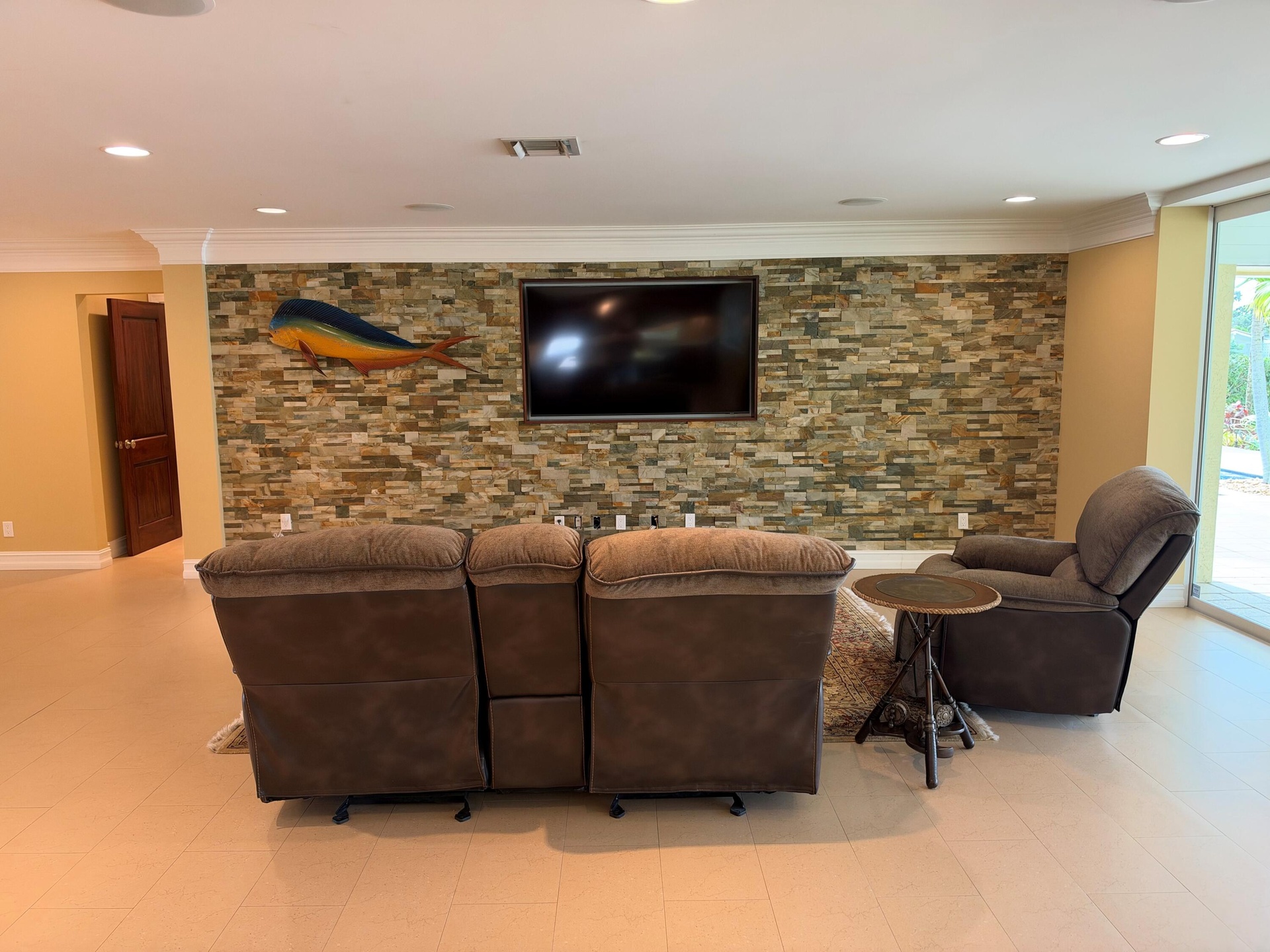 Living room wall has a striking rock feature with mahogany framed in sunken TV area