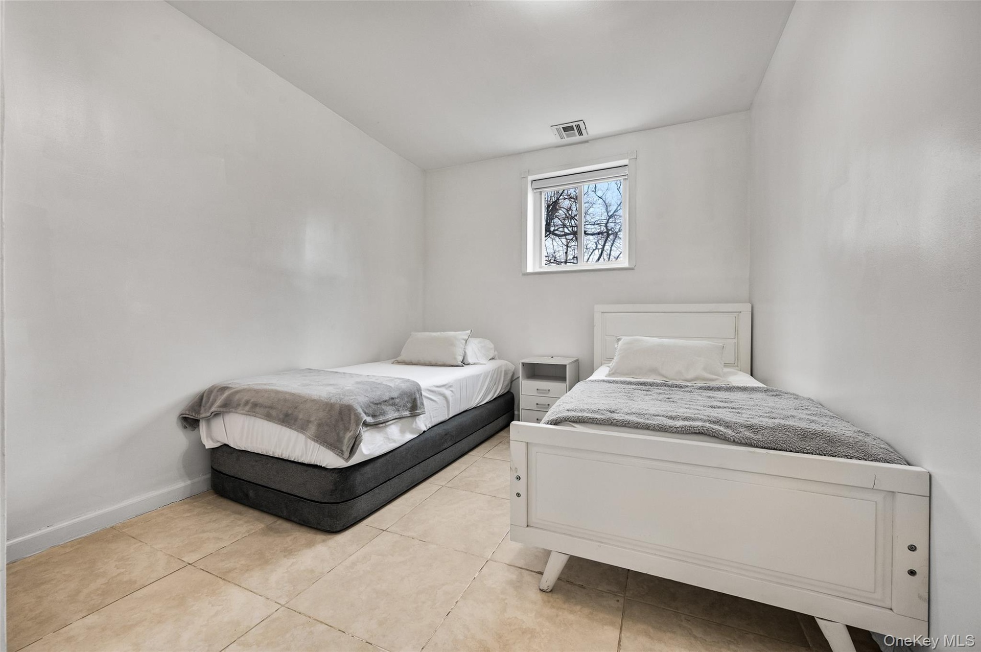 Neutral interior room featuring tile flooring and a single-pane window