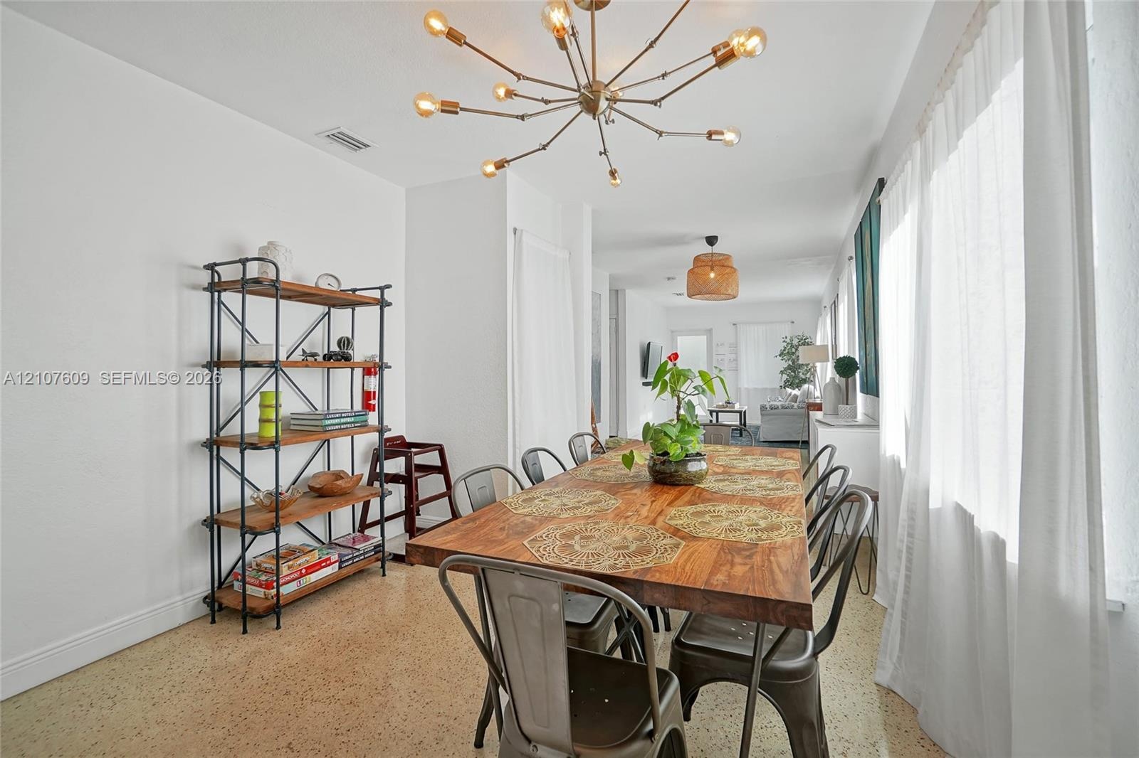 Polished aggregate flooring, multi-arm sputnik chandelier, and expansive windows with natural light