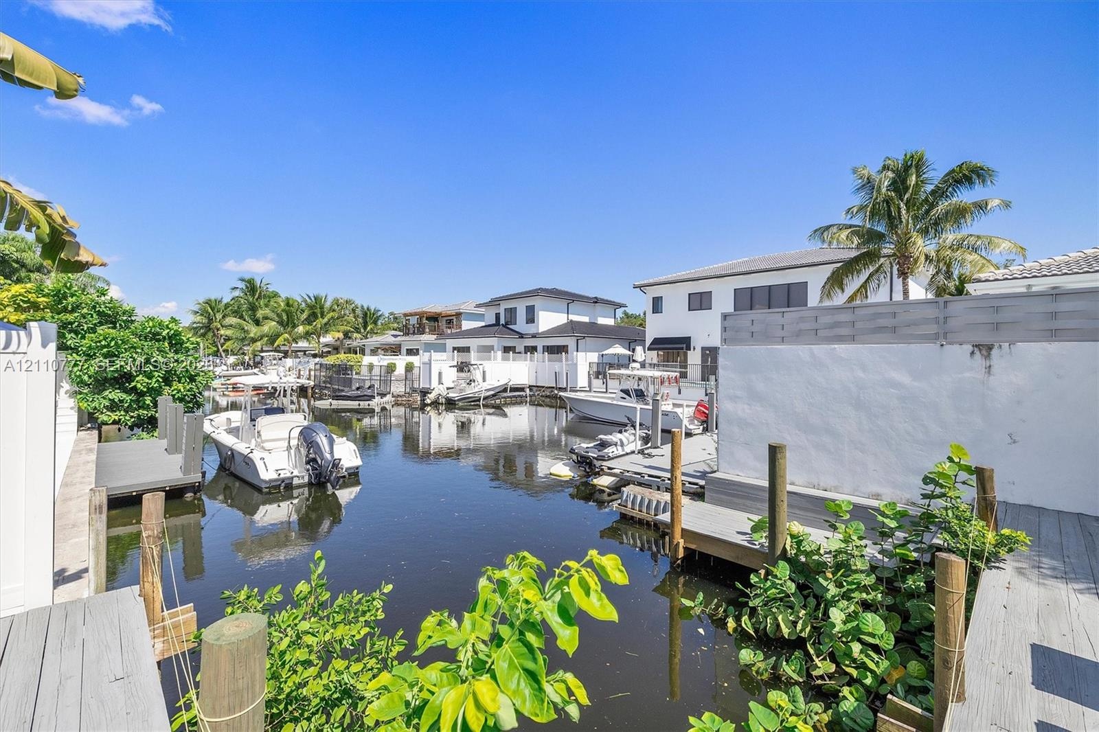 Waterfront property featuring private docks, bulkhead reinforced shoreline, and established tropical landscaping