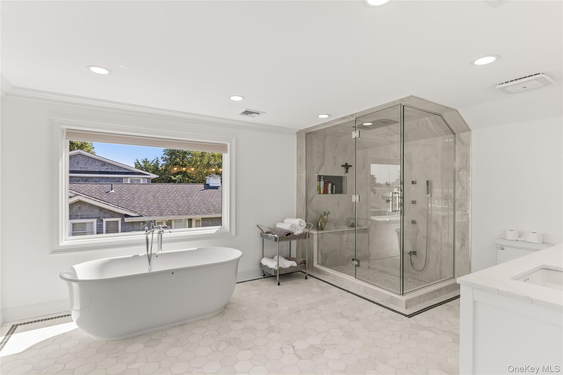 Full bathroom with a freestanding bath, a marble finish shower, vanity, recessed lighting, and ornamental molding
