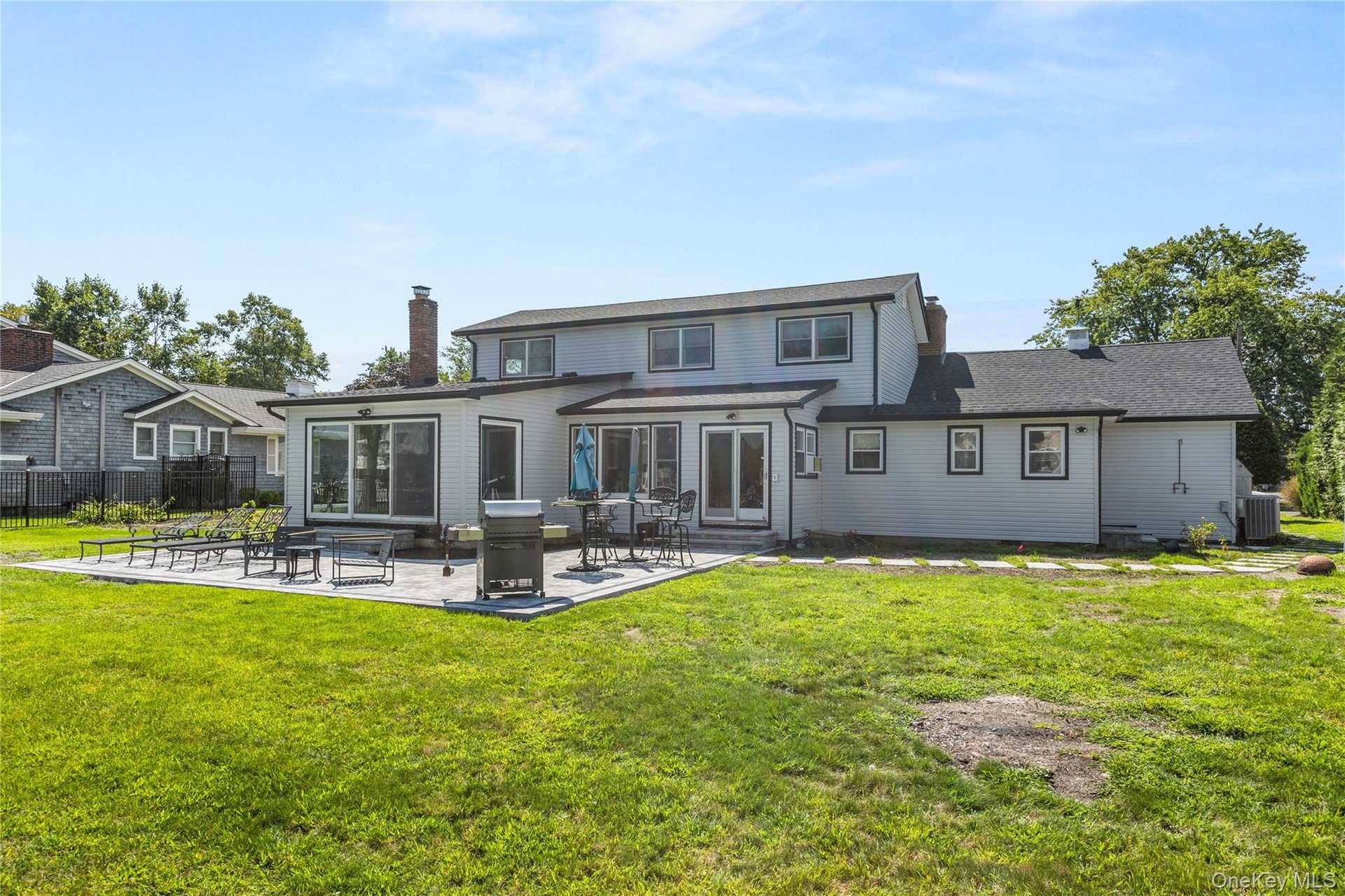 Back of house with a patio area and a chimney