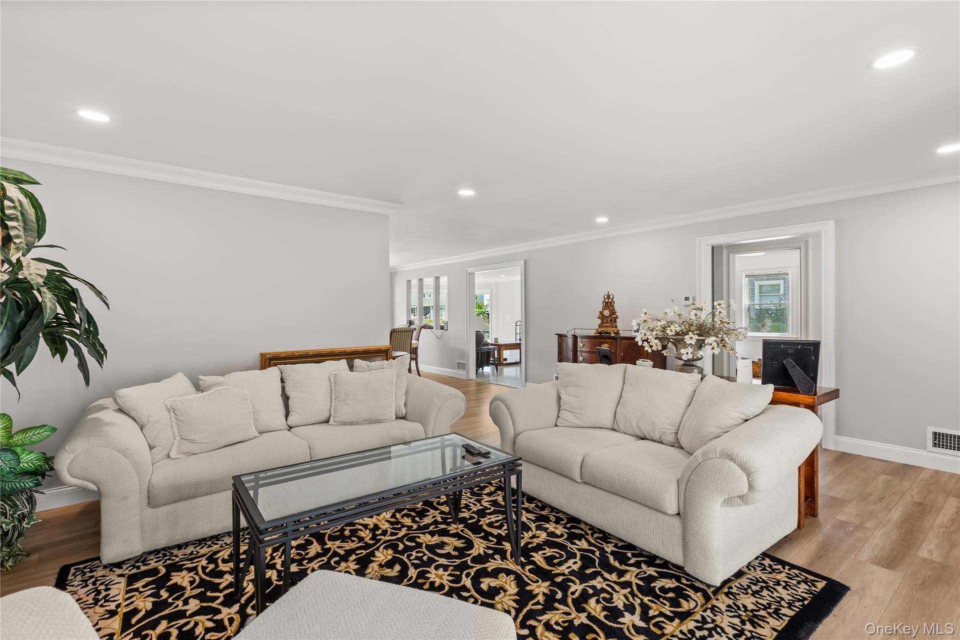 Living area featuring light wood-style flooring, recessed lighting, and crown molding