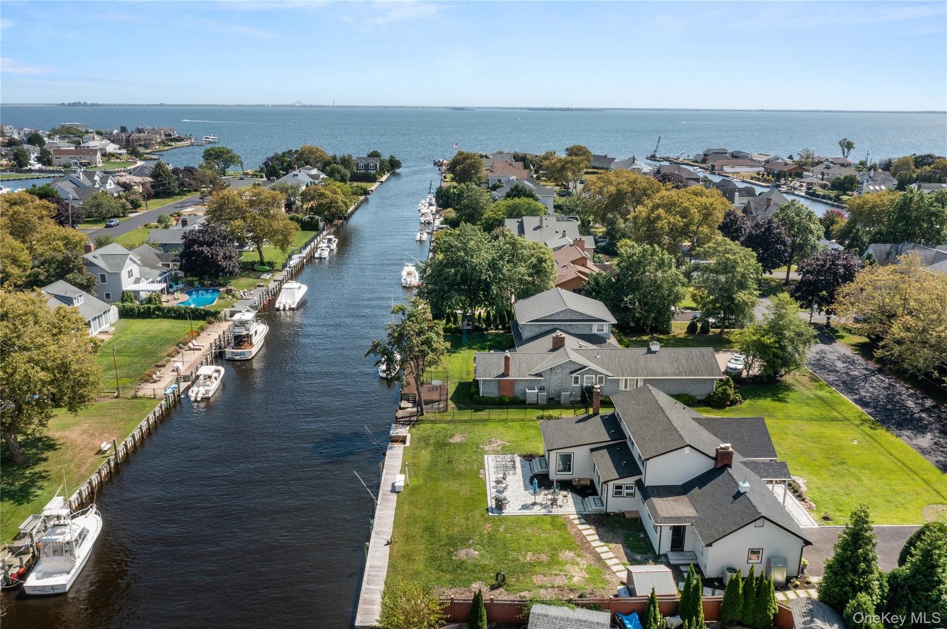 Aerial view of property's location featuring a nearby body of water and nearby suburban area
