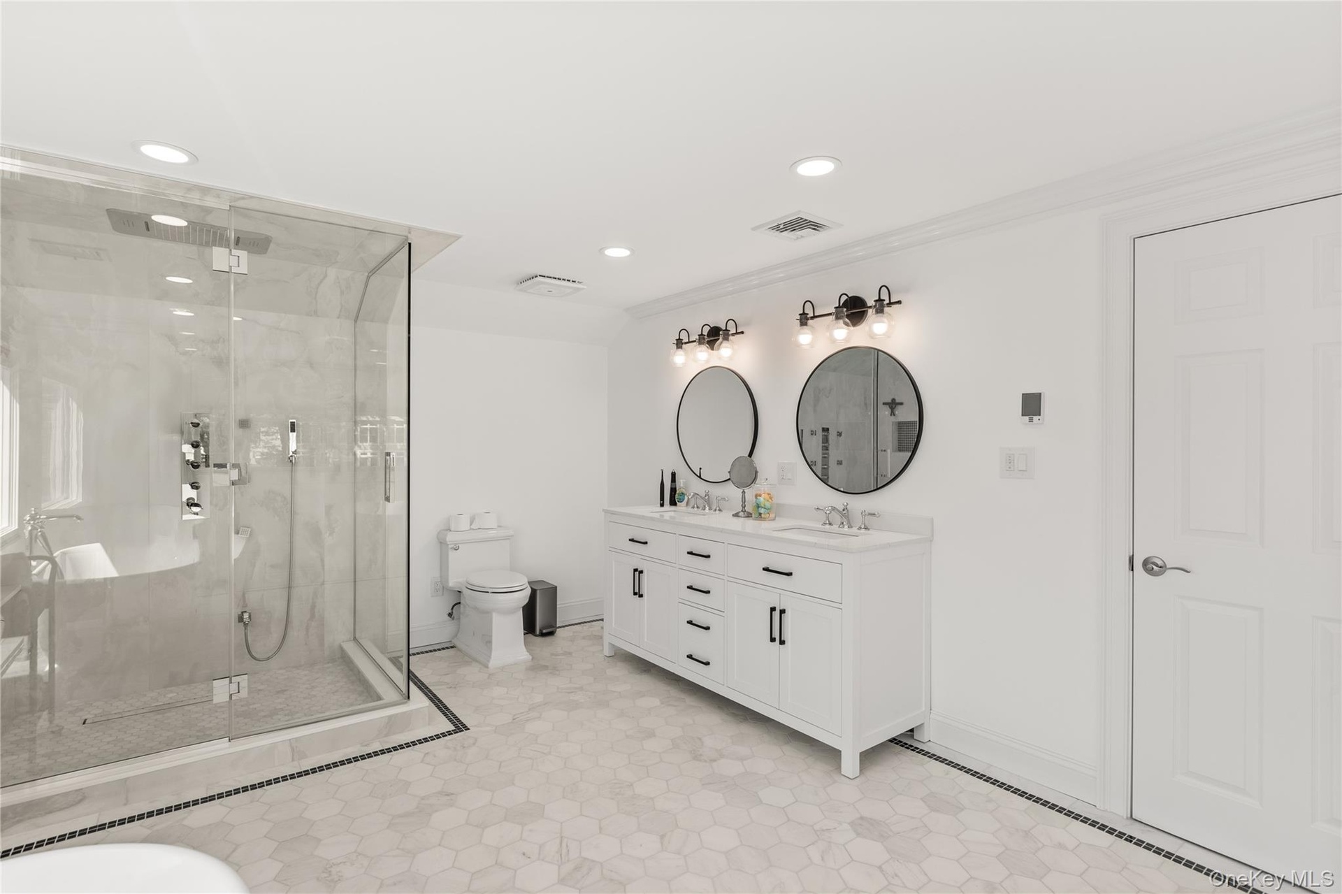Bathroom with a marble finish shower, double vanity, recessed lighting, and ornamental molding