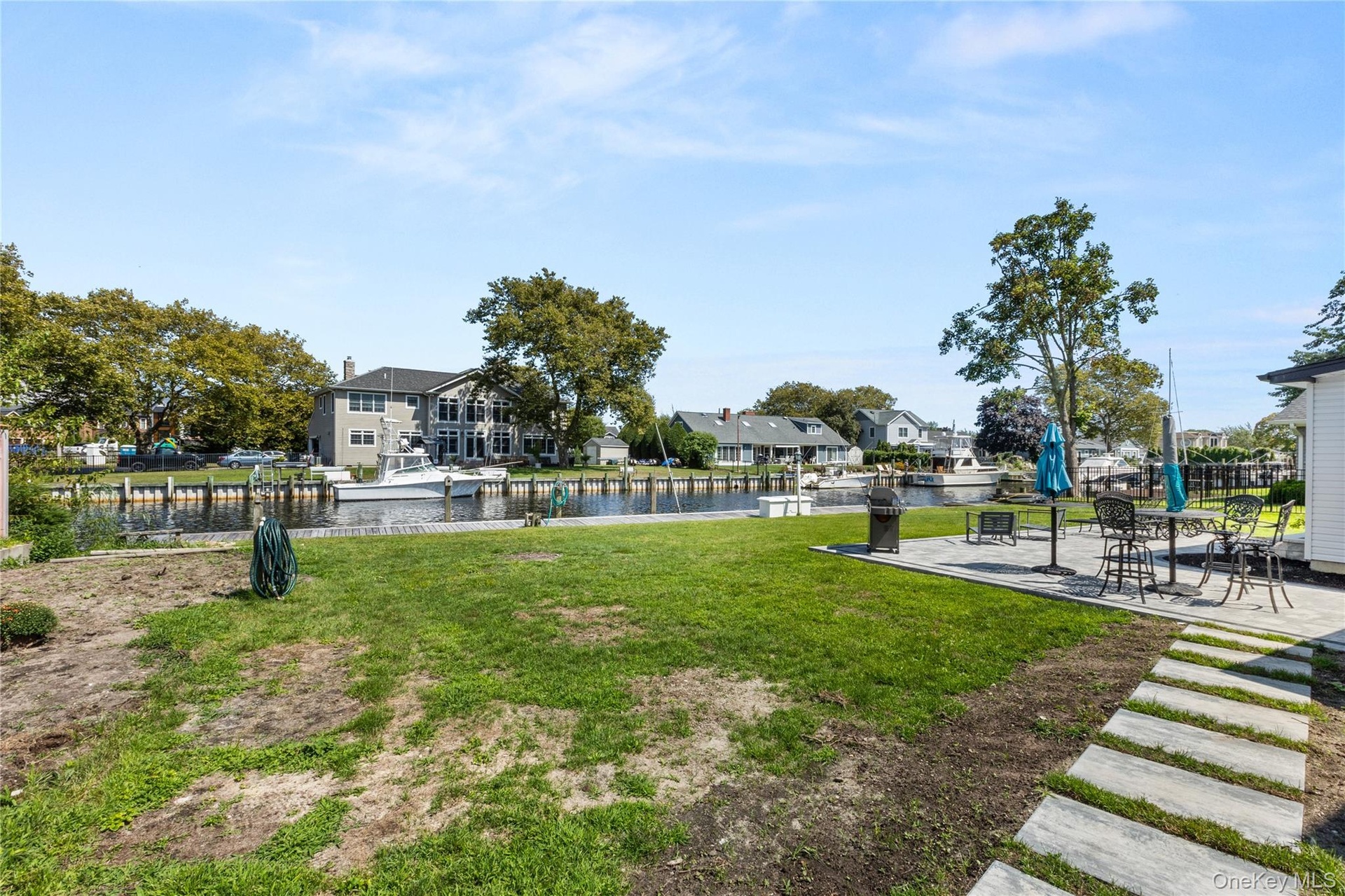View of property's community featuring a water view, a residential view, a yard, and a patio