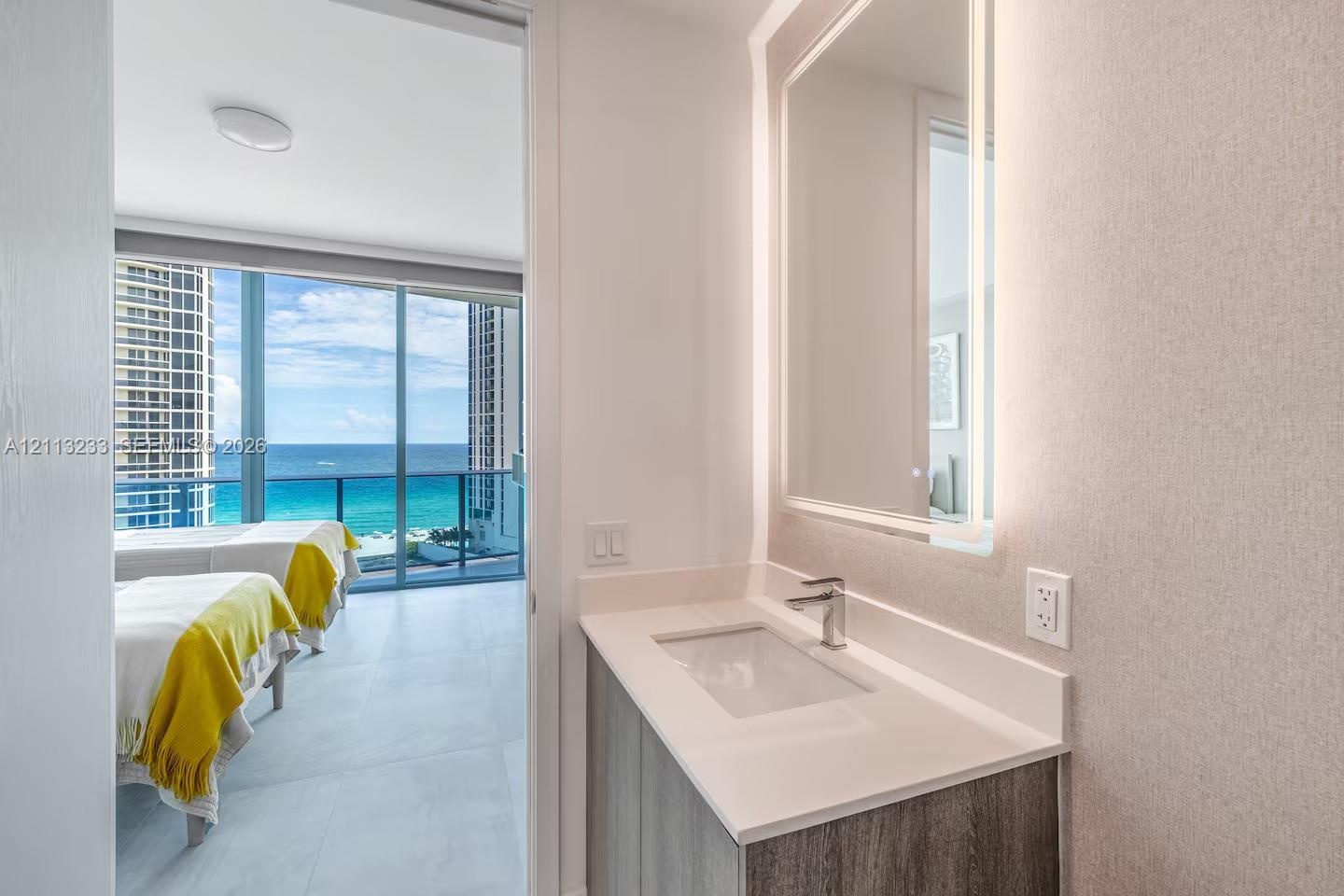 Modern vanity featuring a rectangular integrated sink, quartz countertop, and a wall-mounted LED mirror
