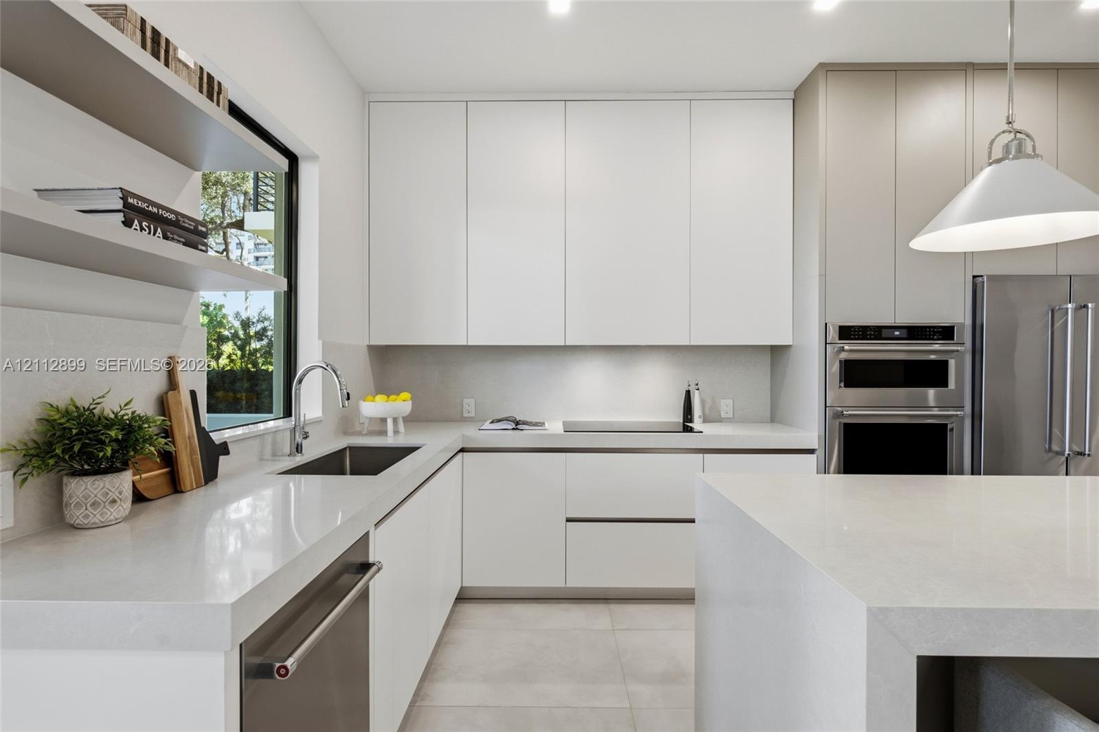 Modern kitchen featuring flat-panel cabinetry, light-toned stone countertops, built-in stainless steel appliances, dual open floating shelves, and an 