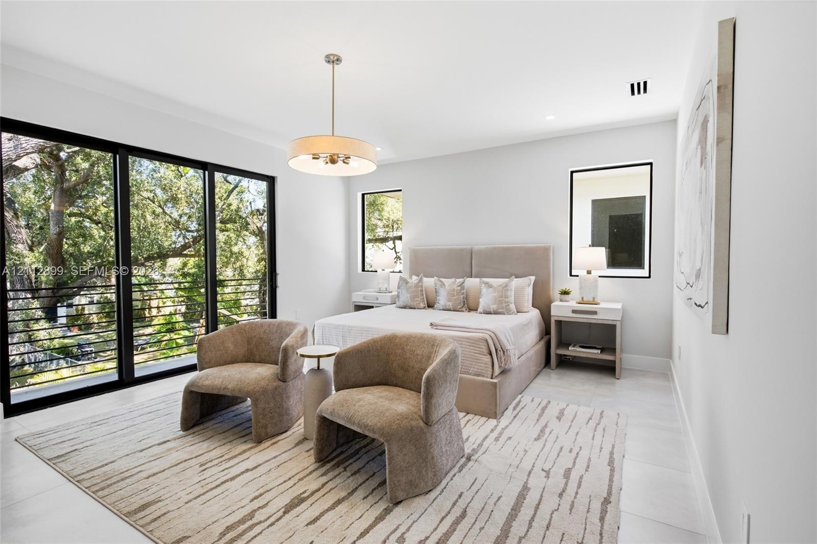 Large format sliding glass doors, polished stone flooring, drum pendant lighting, and oversized windows