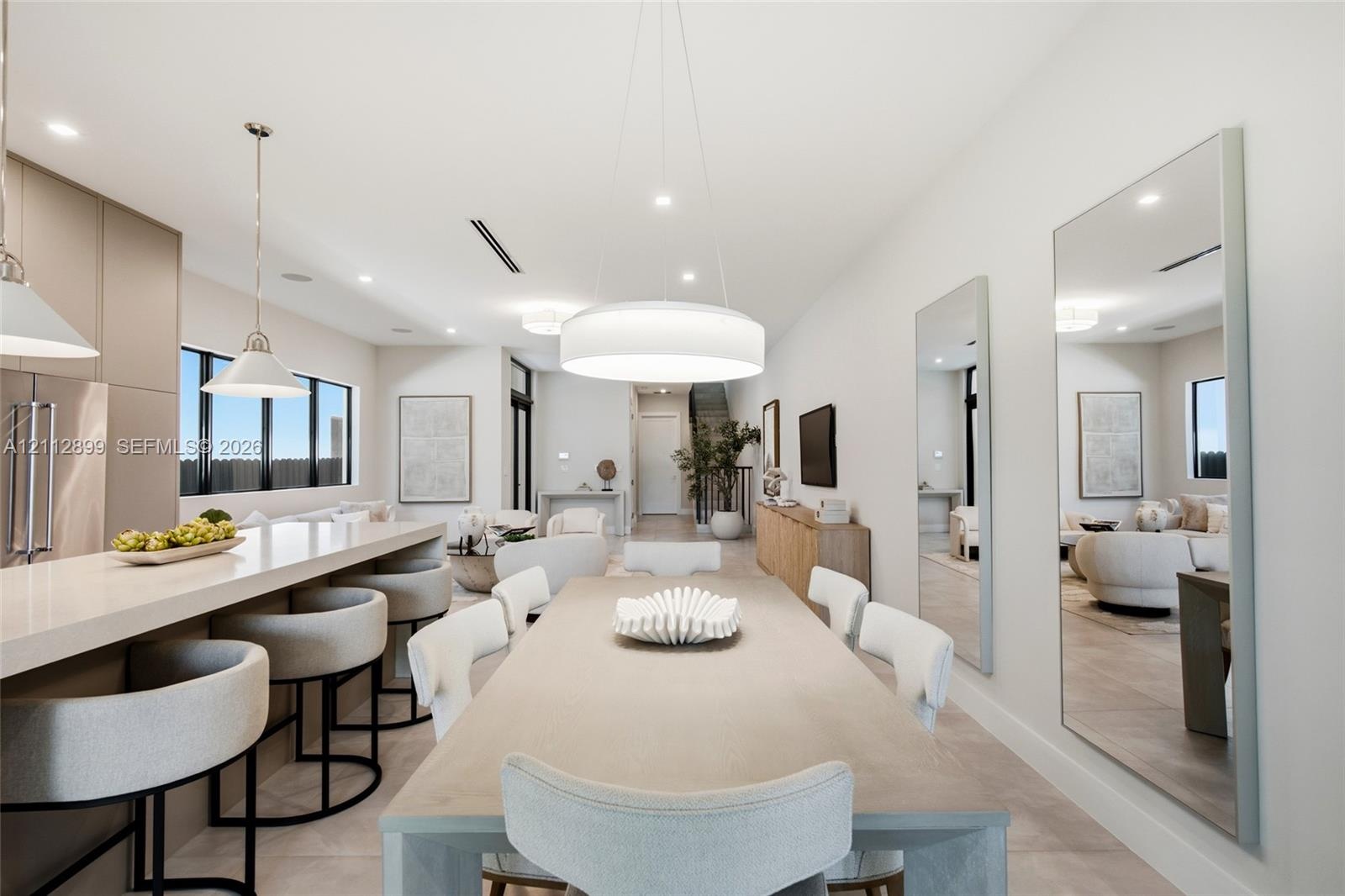 Open-concept interior featuring a kitchen island with stone countertop, large-scale drum pendant lighting, flush-mount recessed ceiling lights, and wa