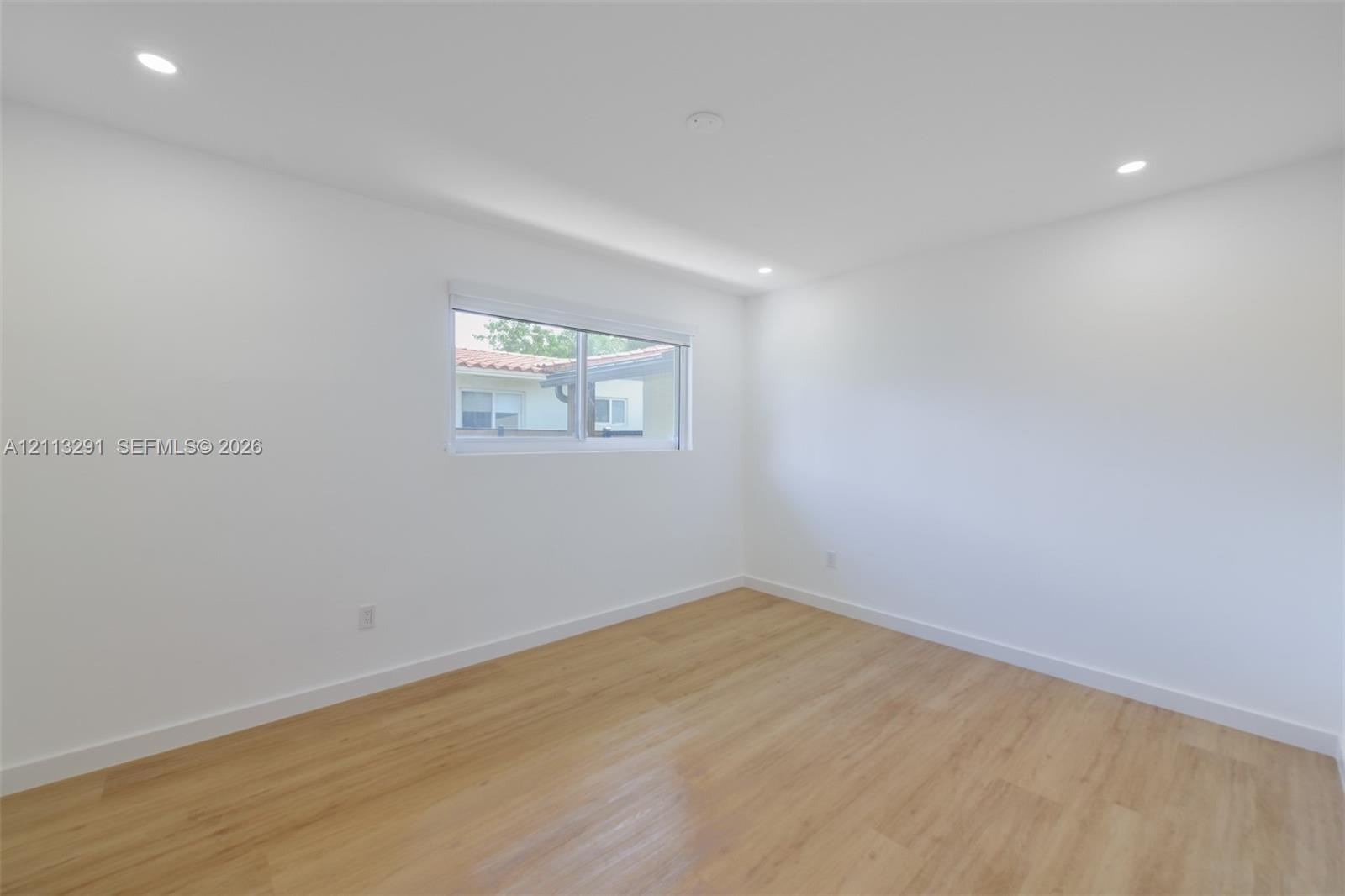 Interior space featuring recessed lighting, wood-finish flooring, and a sliding window