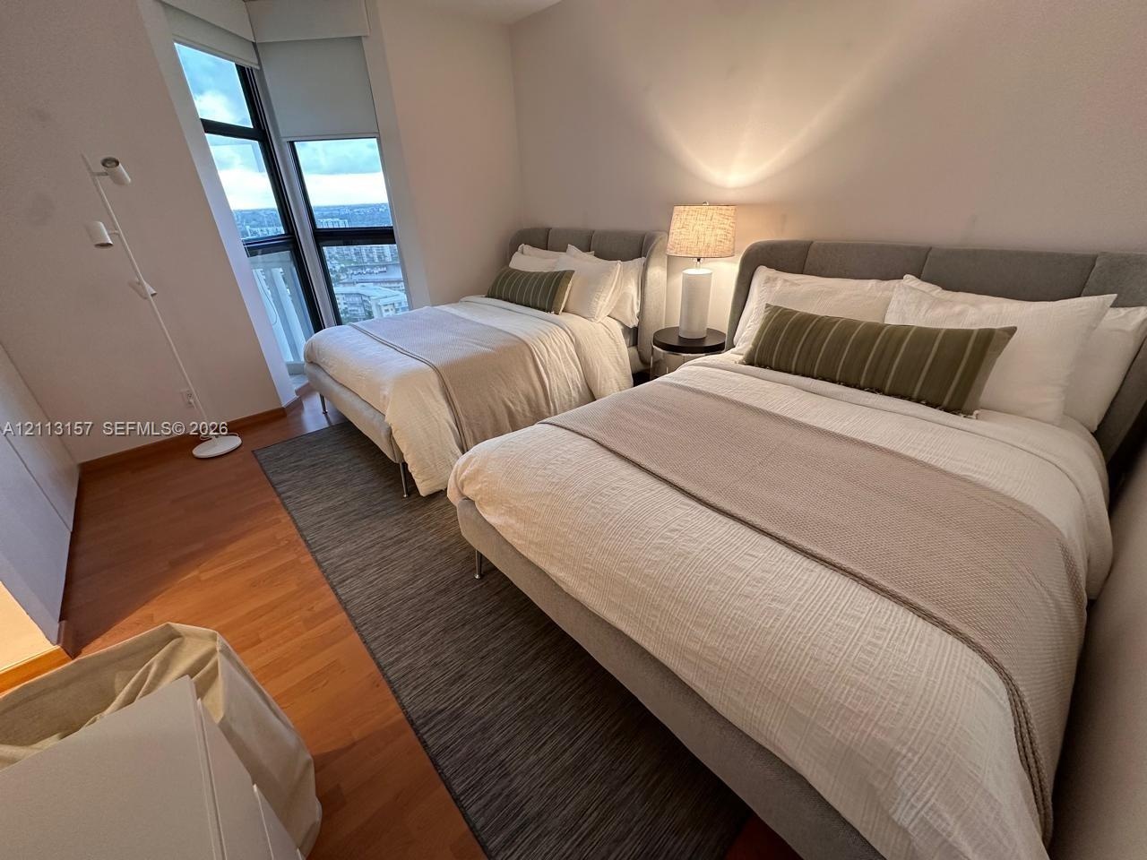 Floor-to-ceiling windows with expansive glass panels and wood-finish flooring