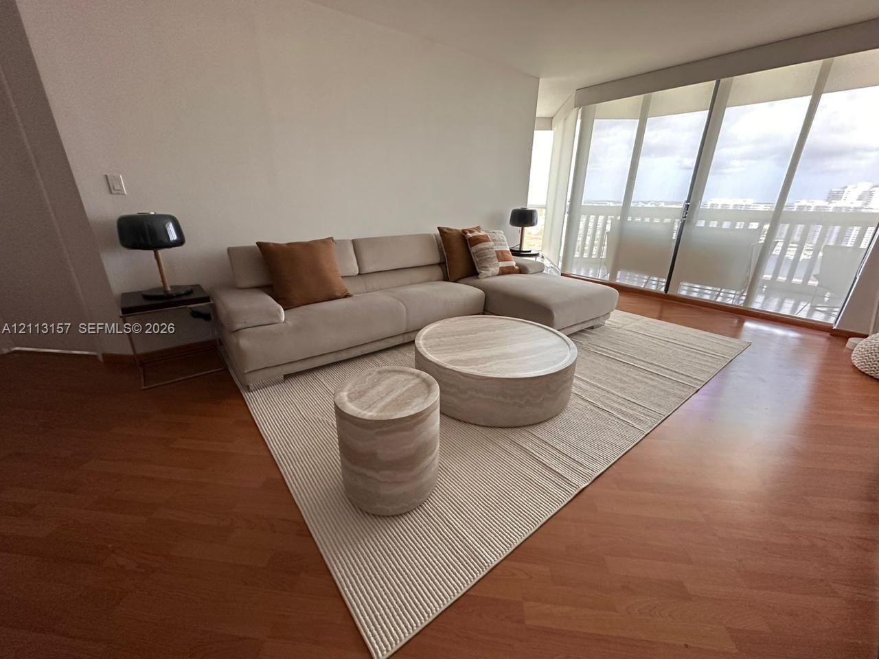 Floor-to-ceiling windows featuring sliding glass doors and wood-finish flooring