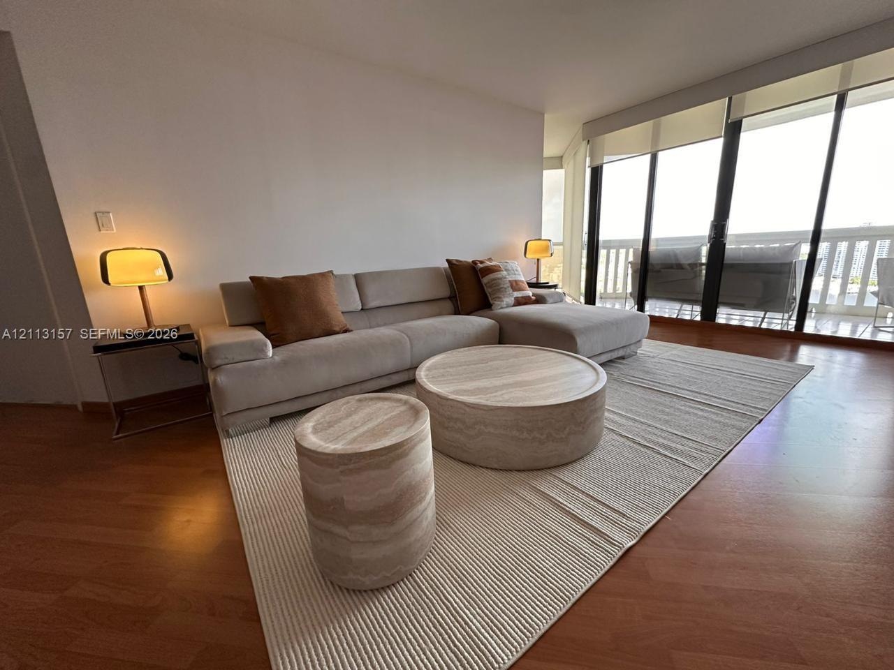 Floor-to-ceiling glass sliding doors, wood-finish flooring, and natural light