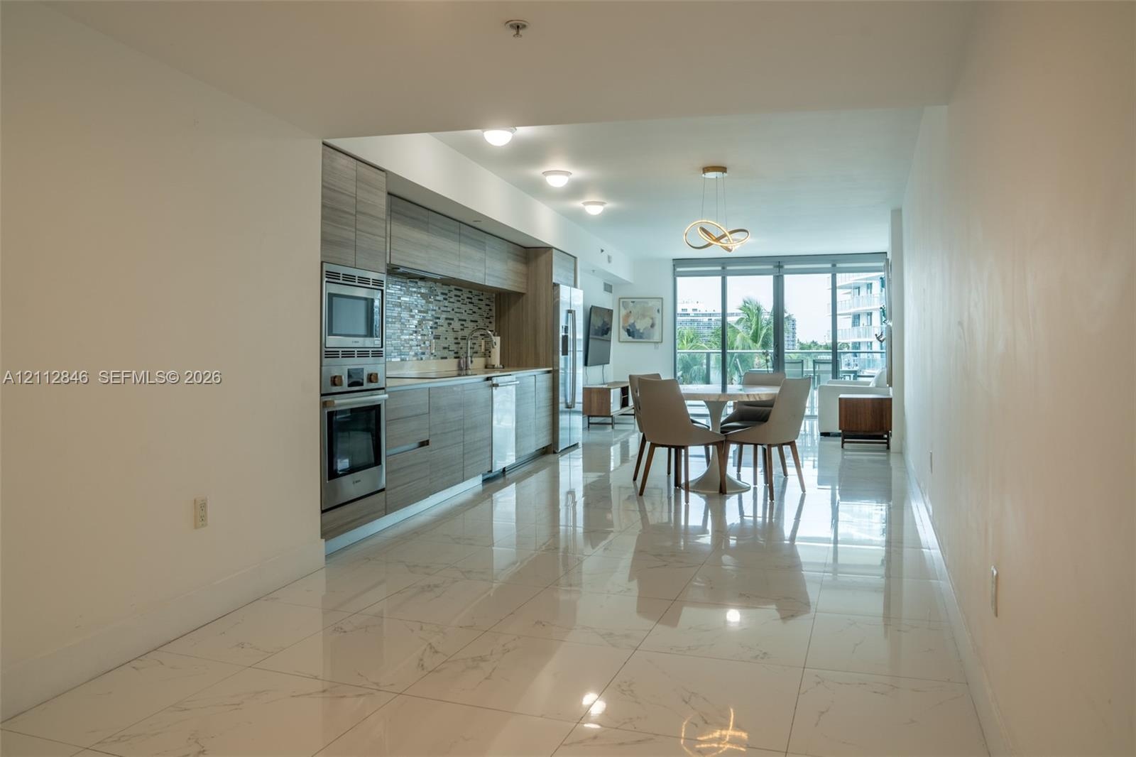 Kitchen featuring horizontal-grain cabinetry, stainless steel wall oven and microwave, mosaic tile backsplash, and floor-to-ceiling glass panel window