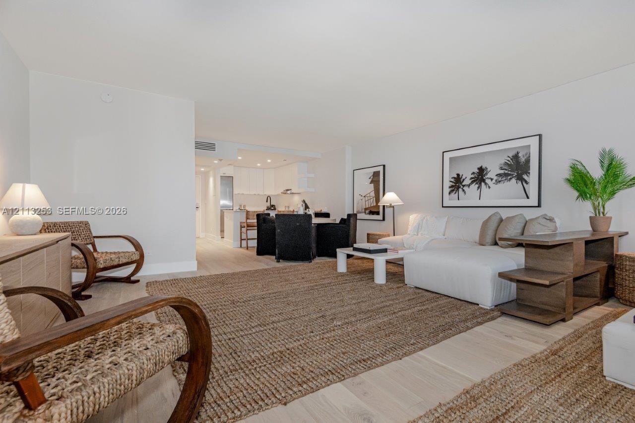 Open-concept interior featuring light wood-finish flooring, recessed lighting, and white cabinetry