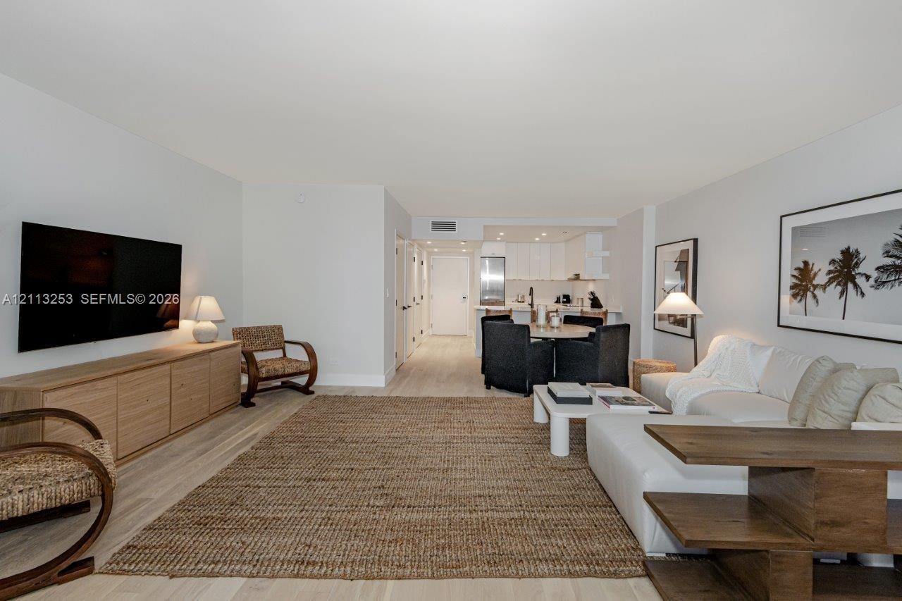 Open-concept interior featuring light wood-finish flooring, recessed lighting, and crisp neutral wall color