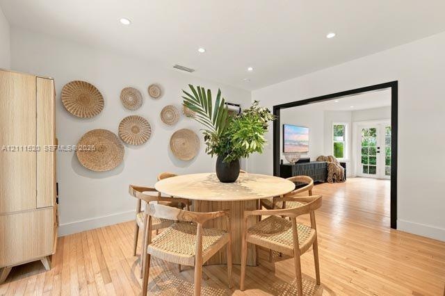 Wood-finish flooring, recessed lighting, and a prominent doorway featuring high-contrast black trim