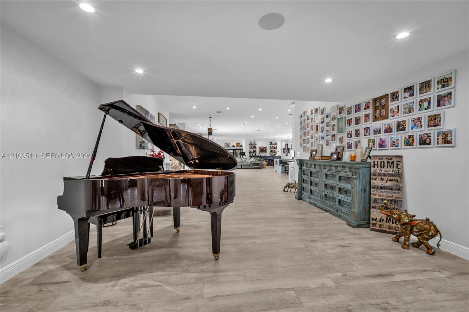 Open-concept interior featuring light-toned wood-finish flooring and recessed ceiling lighting