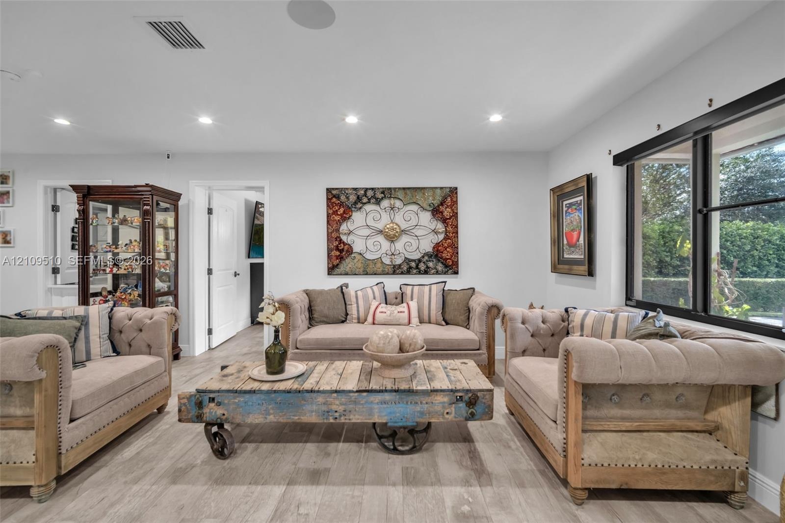 Interior space featuring wood-finish flooring, recessed lighting, and large windows with black frames