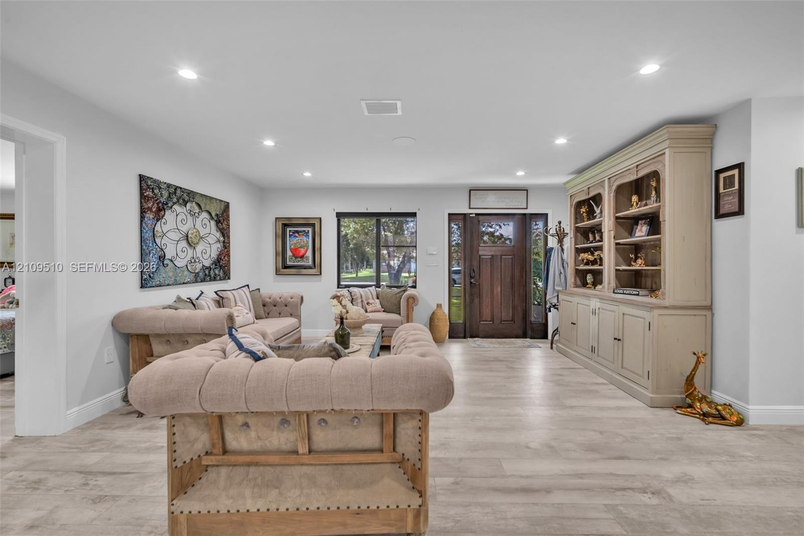 Interior space featuring wood-finish flooring, recessed lighting, and a stained wood front door with sidelights